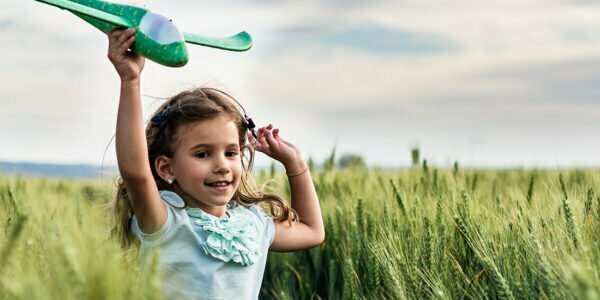 Flicka leker med grön flygplan